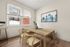 Bright and modern dining room with large windows, stylish wooden table and chairs, cityscape artwork, and sleek light wood flooring.