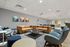 Modern lounge area with chic leather sofas, stylish armchairs, and vibrant abstract art on the walls.