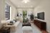 Charming living room with elegant decor, featuring a cozy beige sofa, lush greenery, modern artwork, and a sleek wall-mounted TV.