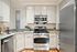 Modern kitchen with sleek stainless steel appliances, granite countertops, and elegant cabinetry.