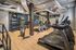 Modern fitness center with state-of-the-art treadmills, exercise bikes, and weightlifting equipment on sleek hardwood flooring.