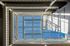 Innovative architectural skylight with a modern glass and metal design, offering a stunning view of the blue sky above.