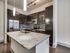 Modern kitchen with elegant dark wood cabinets, sleek stainless steel appliances, and a chic marble countertop island.