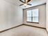 Bright and airy bedroom with a sleek ceiling fan and large window, perfect for relaxation.