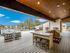 Enchanting rooftop terrace offering stylish seating, outdoor kitchen, and expansive views, perfect for entertaining under a bright blue sky.