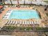 Inviting outdoor oasis featuring a sparkling swimming pool surrounded by chic lounge chairs and vibrant landscaping.