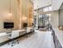 Modern apartment lounge with sleek workstations, large windows, and contemporary lighting, perfect for productivity and relaxation.