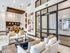 Elegant apartment lobby with modern decor, featuring plush seating, a stylish dining area, and contemporary artwork.