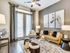 Chic and cozy living room with large windows, elegant decor, and contemporary art piece above a stylish sofa.