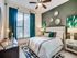 Chic bedroom with plush bedding, elegant decor, and large window offering natural light.