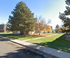 Charming apartment complex with lush green lawns and mature trees creating a serene environment.