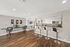 Chic and modern apartment space featuring a stylish breakfast bar, ergonomic workspace, and sleek wood flooring.