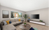 Inviting living room with a cozy sectional sofa, vibrant decor accents, and large window offering garden views.