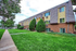 Charming mid-century apartment complex with lush green lawns and modern architecture, perfect for relaxed living.