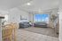 Bright and airy living space with modern furnishings, large windows, and spacious tiled floor, perfect for comfortable living and entertaining.