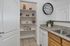 Charming kitchen with pantry showcasing granite countertops, spacious shelving, and modern accents.