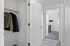 Chic apartment hallway with a stylish closet, showcasing modern doors and leading into a bright room with large window views.