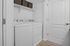 Chic and practical laundry room with stackable washer and dryer, complemented by sleek shelving for organized storage.