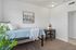 Inviting bedroom with cozy bed, stylish artwork, and functional desk area, perfect for a tranquil retreat.