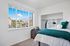 Bright bedroom with large window offering scenic mountain views, modern decor, and ample closet space.