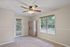 Bright and airy room featuring a sleek ceiling fan, large windows with blinds, and plush carpet flooring, perfect for a cozy retreat.