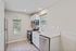 Bright and modern kitchen with sleek countertops, stainless steel appliances, and arched window providing natural light.