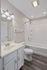 Elegant bathroom with modern fixtures, featuring a pristine white bathtub, sleek vanity with ample storage, and soft ambient lighting.