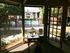Inviting apartment view with glass door opening to a serene courtyard featuring a lush garden and a sparkling pool, perfect for relaxation.