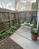 Charming garden patio featuring a cozy bistro set surrounded by colorful blooming flowers and lush greenery.
