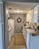 Charming and cozy kitchen with modern white cabinetry, stylish decor, and efficient appliances in an inviting apartment.