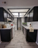 Chic galley kitchen with sleek black cabinets, modern appliances, and stylish decor, offering ample counter space and bright lighting.