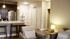 Modern apartment interior featuring a cozy living room with stylish decor and an open kitchen with sleek countertops and stainless steel appliances.