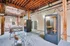 Modern apartment space featuring contemporary glass desks, cozy seating area, and unique phone booths under a stylish exposed beam ceiling.