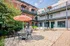 Charming courtyard with stylish patio furniture and vibrant umbrella, surrounded by rustic brick building and modern balconies.