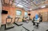 Chic fitness center with modern exercise equipment, exposed brick walls, and large windows for natural light.