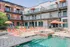 Chic urban apartment with a vibrant outdoor pool area, featuring sun loungers and poolside seating, set against a stylish multi-story building.