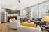 Modern open-concept living area with sleek kitchen, cozy seating, and abundant natural light.