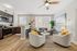 Chic open-concept living space featuring a modern kitchen with dark wood cabinets and a cozy living room with stylish decor and a plush sofa.