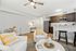 Bright, modern living area with stylish decor, featuring a cozy sofa, elegant dining set, and a sleek kitchen with dark wood cabinetry.