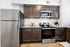 Modern kitchen with elegant dark wood cabinets, stainless steel appliances, and sleek granite countertops.