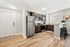 Contemporary kitchen with stainless steel appliances, sleek dark wood cabinetry, and a functional breakfast bar with seating.