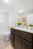 Modern bathroom with elegant dark wood cabinetry, bright white fixtures, and vibrant yellow tulips adding a cheerful touch.