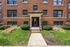 Charming red brick apartment building with well-maintained greenery and a welcoming entrance.