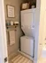 Cozy laundry nook featuring a modern stacked washer and dryer, complemented by stylish decor and ample storage.