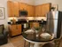 Charming kitchen with wooden cabinetry, sleek stainless steel appliances, and cozy dining setup for stylish living.