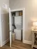 Charming in-unit laundry nook with stacked washer and dryer, featuring stylish decor and ample storage.