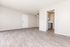 Bright and spacious living area with modern wood flooring and sleek kitchen access.
