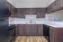 Modern kitchen with sleek dark cabinetry, spacious countertops, and stainless steel appliances, perfect for culinary enthusiasts.
