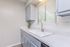 Bright and modern kitchen with sleek gray cabinets, elegant speckled countertops, and a large window allowing natural light.