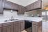 Modern kitchen with elegant dark wood cabinetry, sleek countertops, and a convenient breakfast bar, creating a welcoming atmosphere.